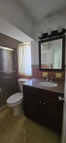 a bathroom with a sink vanity mirror and toilet