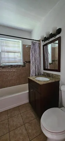 a bathroom with a granite countertop sink toilet and bathtub