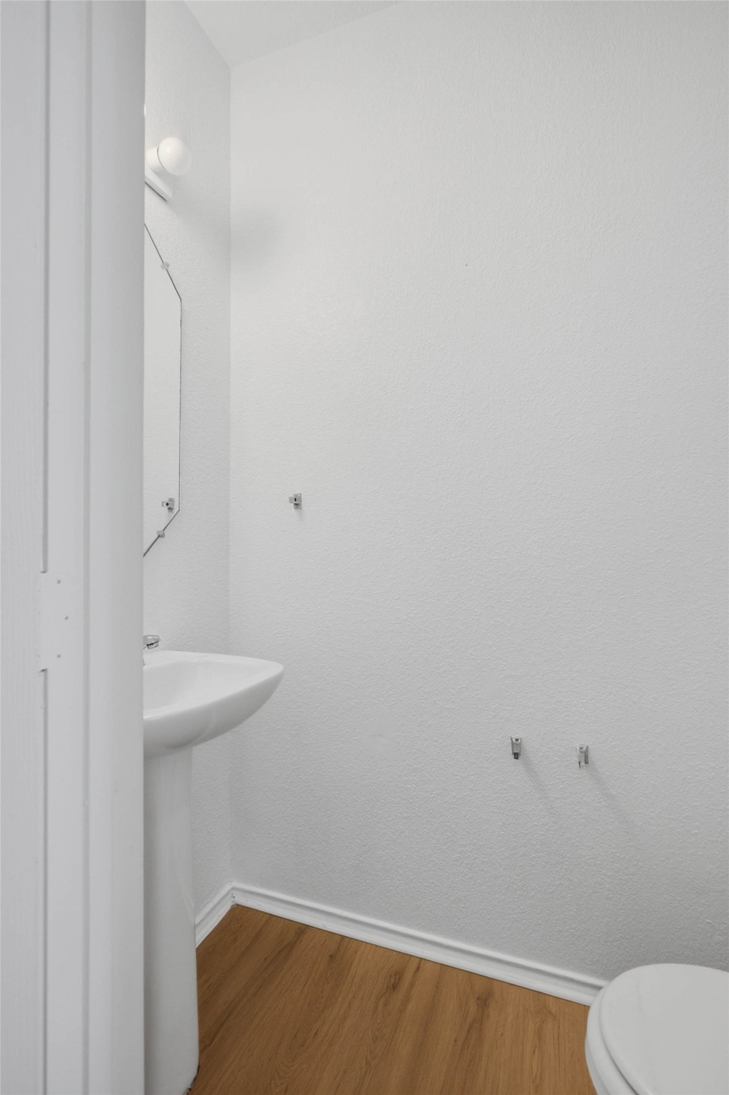 13808 Harris Ridge Boulevard, Unit B Pflugerville, TX 78660 - Photo 14 of 33 An efficient powder room features classic wood-style flooring and a clean pedestal sink.