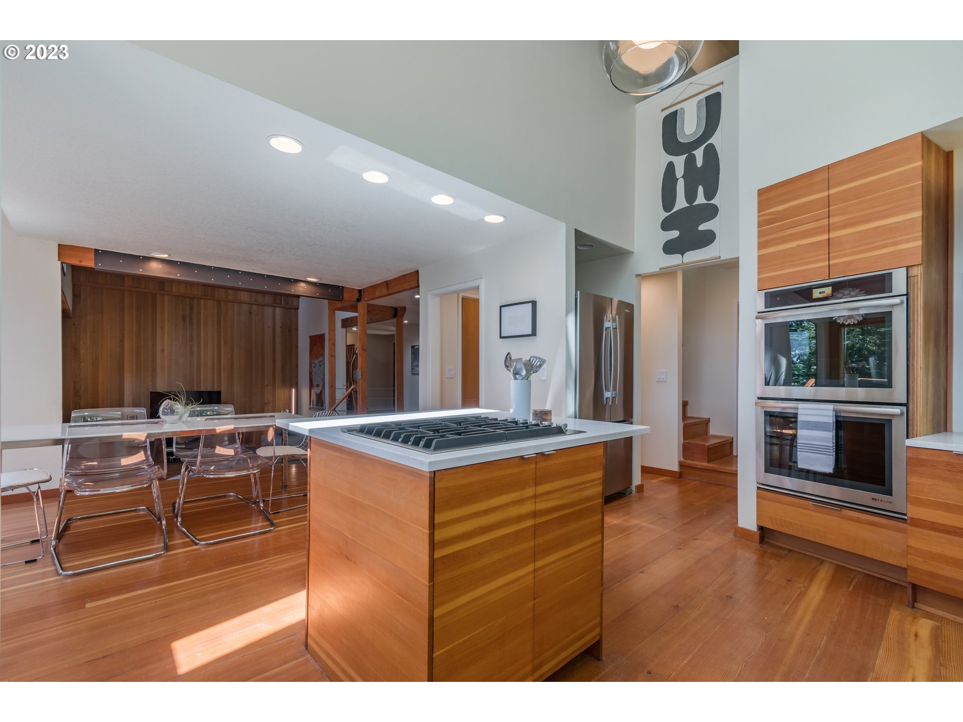 2780 Cresta De Ruta Street Eugene, OR 97403 - Photo 13 of 48 a view of kitchen with kitchen island granite countertop a stove a dining table and chairs with wooden floor