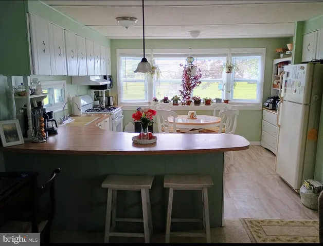 a kitchen with a table chairs refrigerator and cabinets