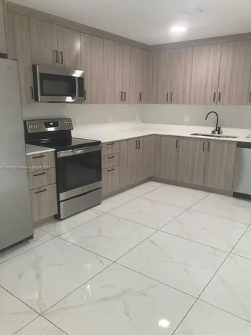 a kitchen with stainless steel appliances granite countertop a sink a stove and cabinets