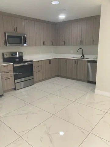 a kitchen with granite countertop a sink and a stove top oven