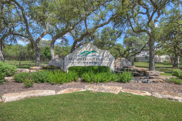 a sign of golf club on a wall under a tree