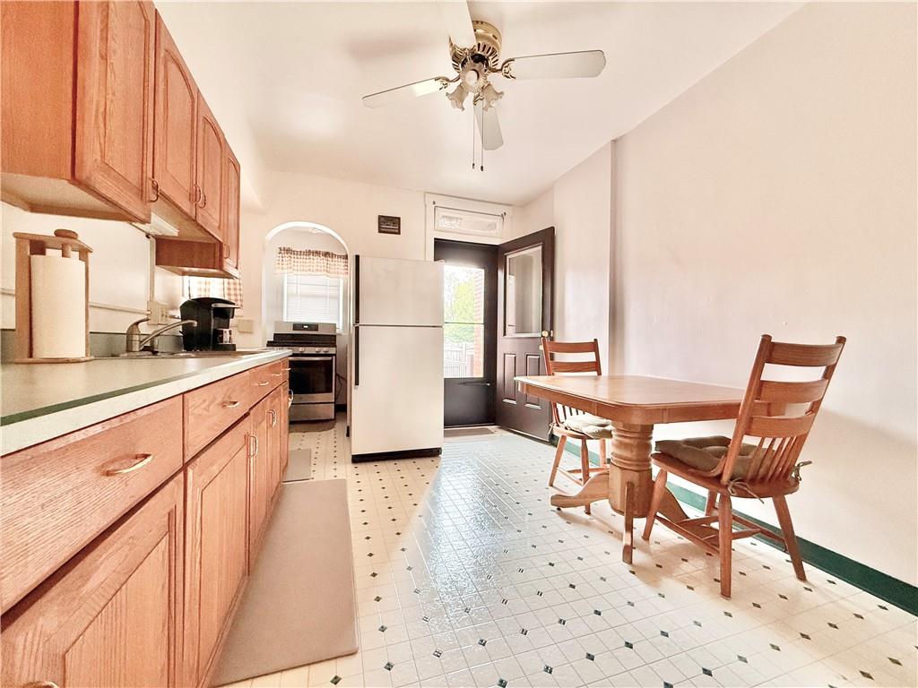3232 California Avenue Pittsburgh, PA 15212 - Photo 13 of 38 a kitchen with stainless steel appliances kitchen island granite countertop a refrigerator a stove a sink dishwasher with a dining table and chairs