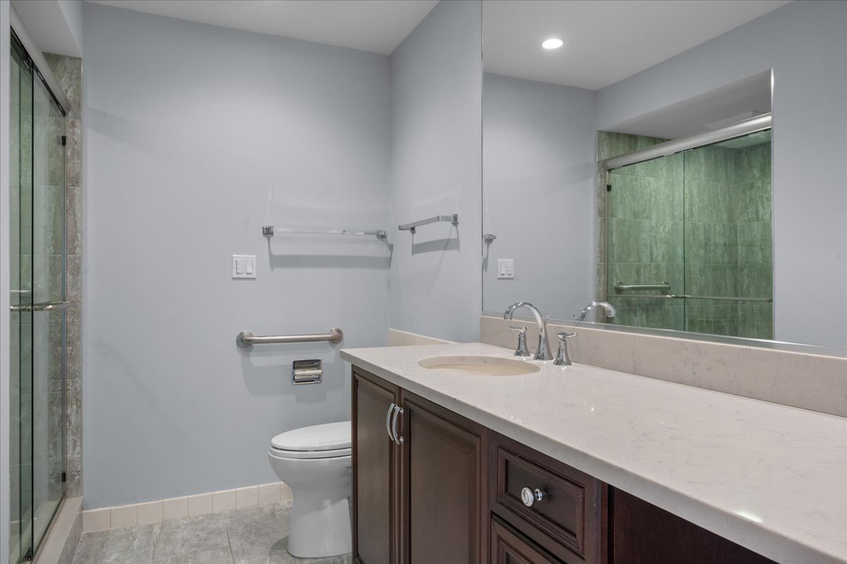1795 Lake Cook Road, Unit 107 Highland Park, IL 60035 - Photo 14 of 26 a bathroom with a sink a toilet and a mirror