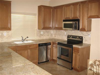67698 Rio Arapaho Road Cathedral City, CA 92234 - Photo 8 of 11 a kitchen with stainless steel appliances granite countertop a stove a microwave a sink and cabinets