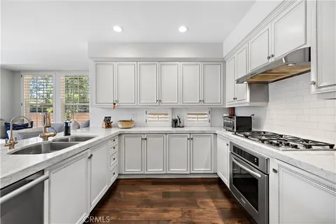 a kitchen with a sink stove top oven and cabinets