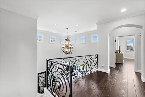 a view of a hallway with wooden floor and windows