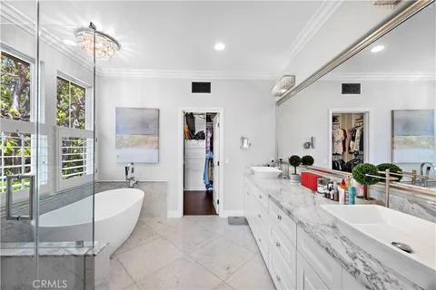 a spacious bathroom with a tub sink and mirror