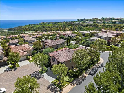 an aerial view of a city with lots of residential buildings ocean and mountain view in back