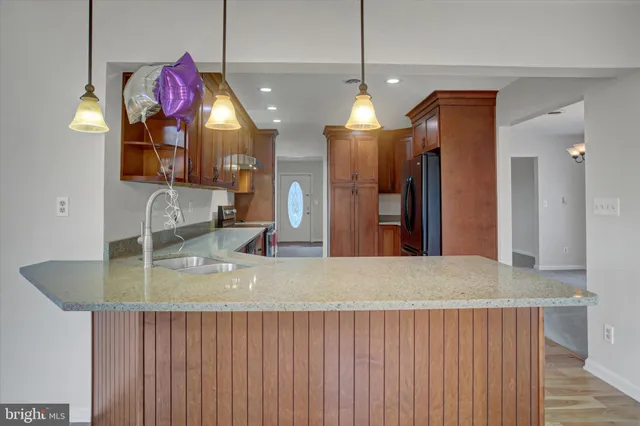 a view of a kitchen with a sink and chandelier