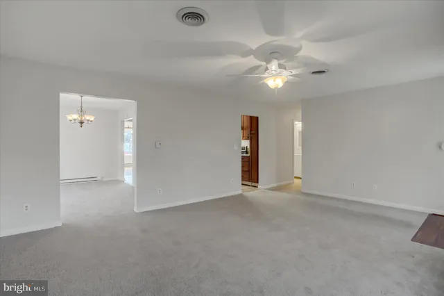 an empty room with closet and a chandelier fan