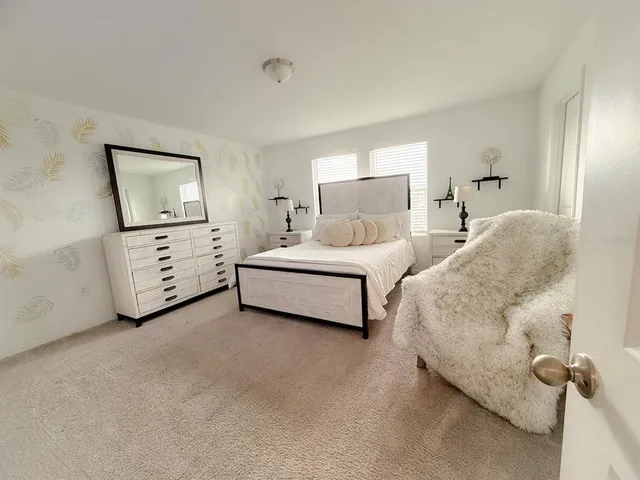 a spacious bedroom with a bed and cabinet