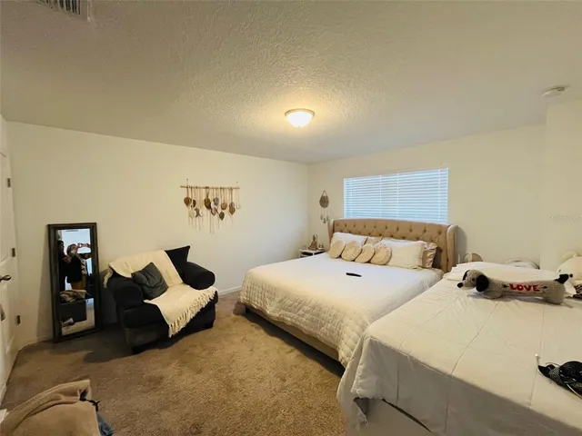 a bed room with a bed furniture and a flat tv screen