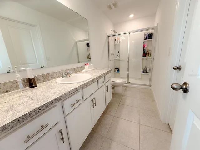 a spacious bathroom with a granite countertop sink mirror and shower