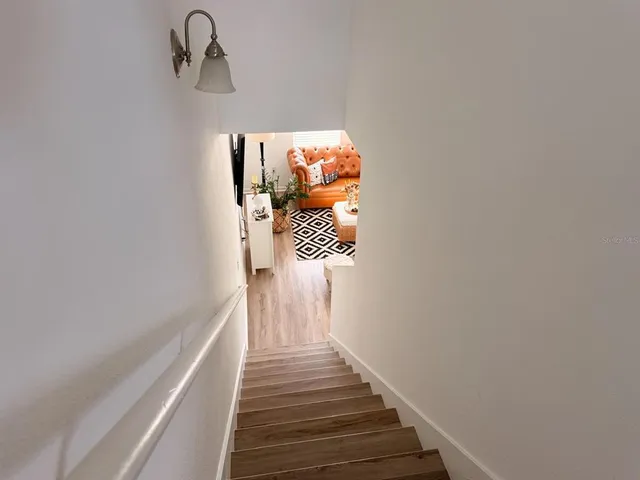 a view of a hallway with wooden floor and staircase