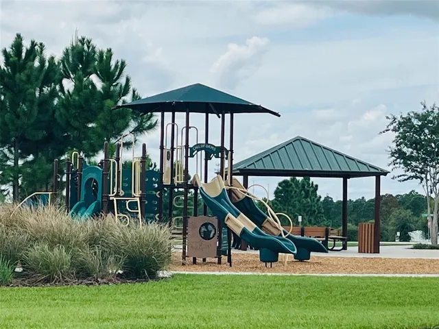 a sign board with tall trees in the background