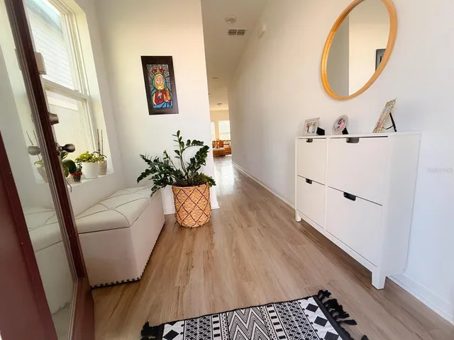 a hallway with wooden floor and a chandelier