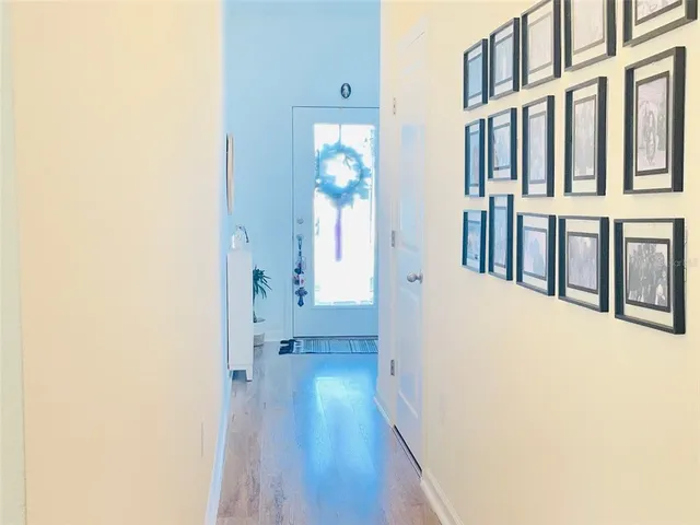 a view of a hallway with wooden floor and staircase