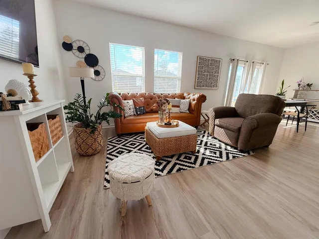 a living room with furniture a couch and wooden floor