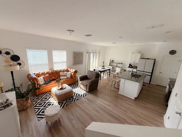a living room with furniture and wooden floor