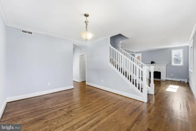 a view of empty room with wooden floor and fireplace