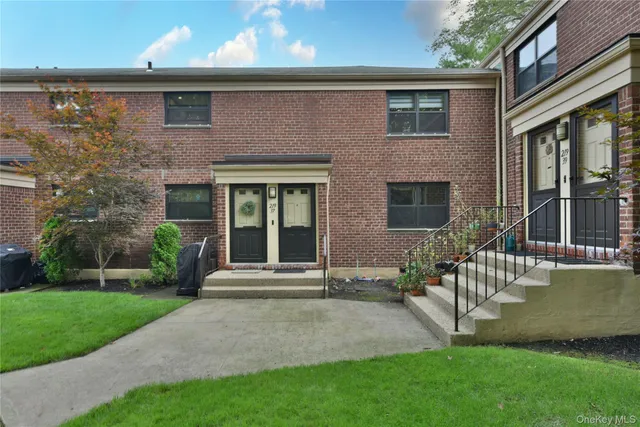 a front view of a house with a yard and glass windows