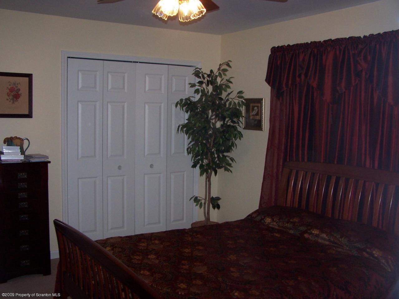 455 Maple Grove Road Factoryville, PA 18419 - Photo 5 of 16 a bedroom with a bed table and a potted plant