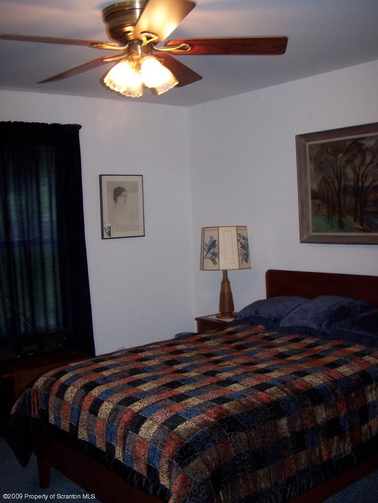 455 Maple Grove Road Factoryville, PA 18419 - Photo 7 of 16 a bedroom with a bed and a chandelier