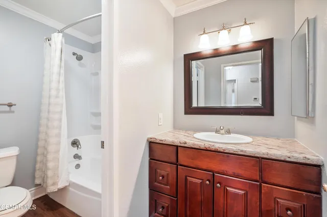 a bathroom with a granite countertop sink toilet a mirror and shower