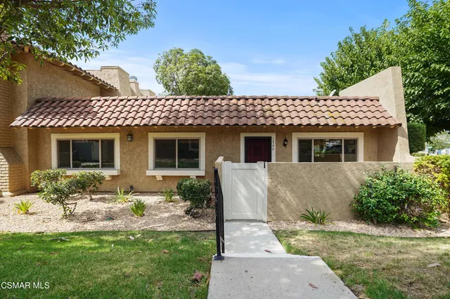 a front view of a house with a garden and yard