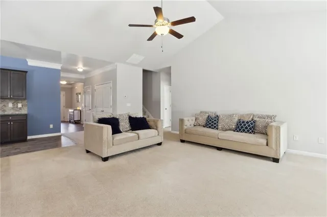 a living room with furniture kitchen view and a chandelier