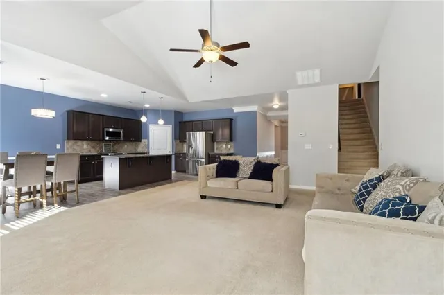 a living room with stainless steel appliances kitchen island furniture and a view of kitchen