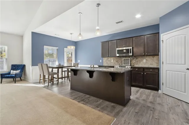 a kitchen with stainless steel appliances granite countertop a sink stove and microwave