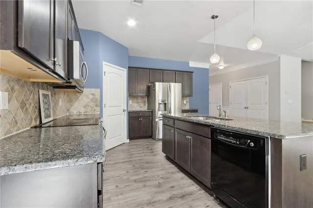 a kitchen with stainless steel appliances granite countertop a sink stove and refrigerator