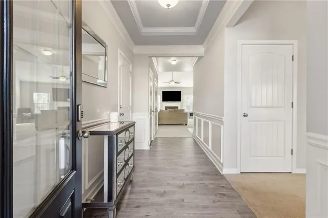 a view of a hallway with wooden floor kitchen view and a living room