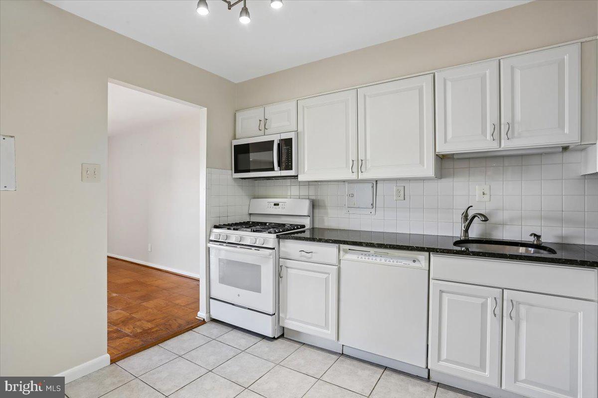 9900 Georgia Avenue, Unit 27613 Silver Spring, MD 20902 - Photo 6 of 47 Kitchen with white cabinets & granite counter tops