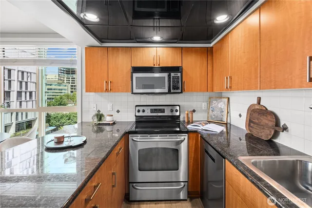 a kitchen with stainless steel appliances granite countertop a granite counter tops and a refrigerator