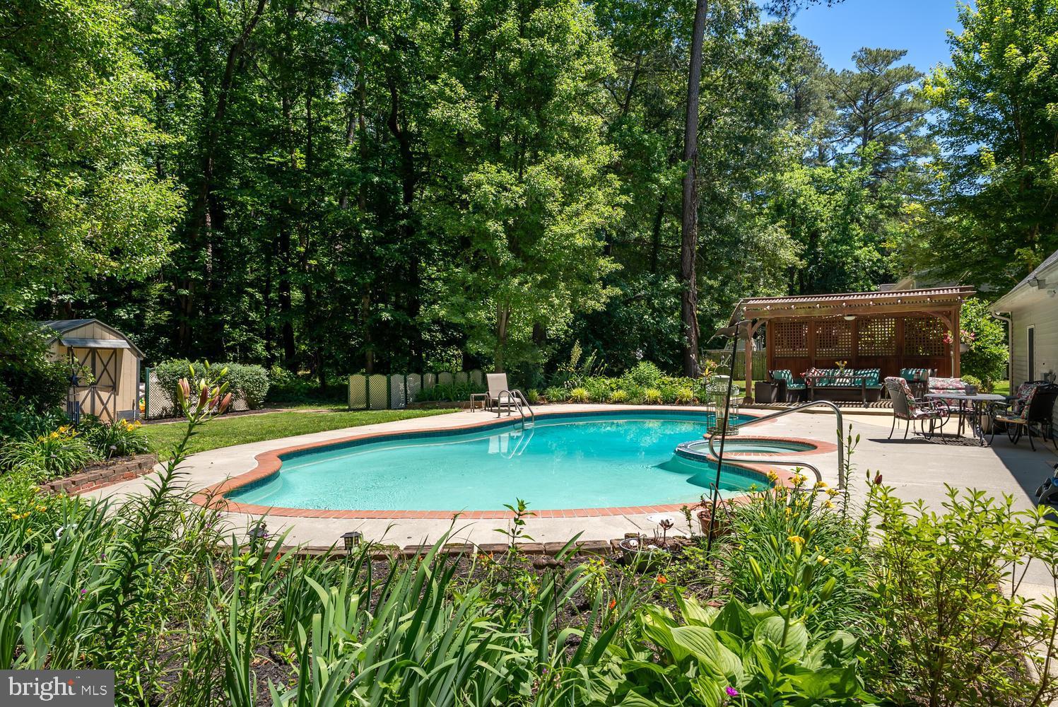 814 Wrights Neck Road Centreville, MD 21617 - Photo 17 of 53 a view of a swimming pool with a patio and a garden