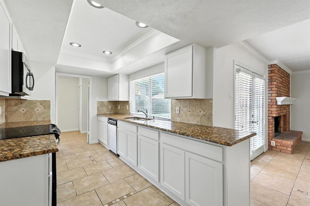 5024 Middleton Circle The Colony, TX 75056 - Photo 13 of 30 a kitchen with granite countertop a sink stove and cabinets