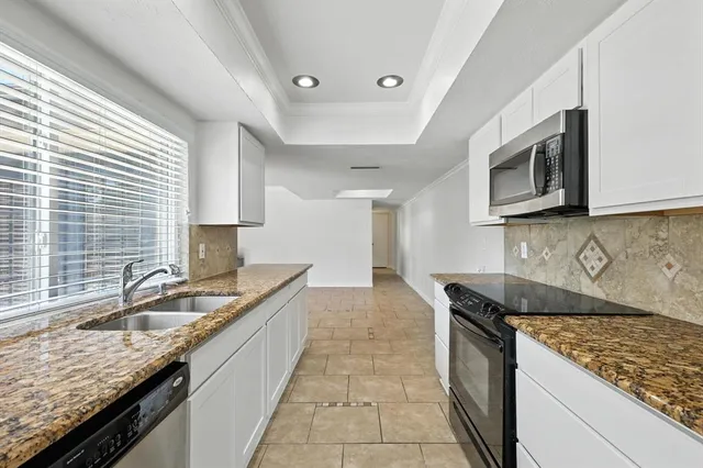 a kitchen with stainless steel appliances granite countertop white cabinets and stove