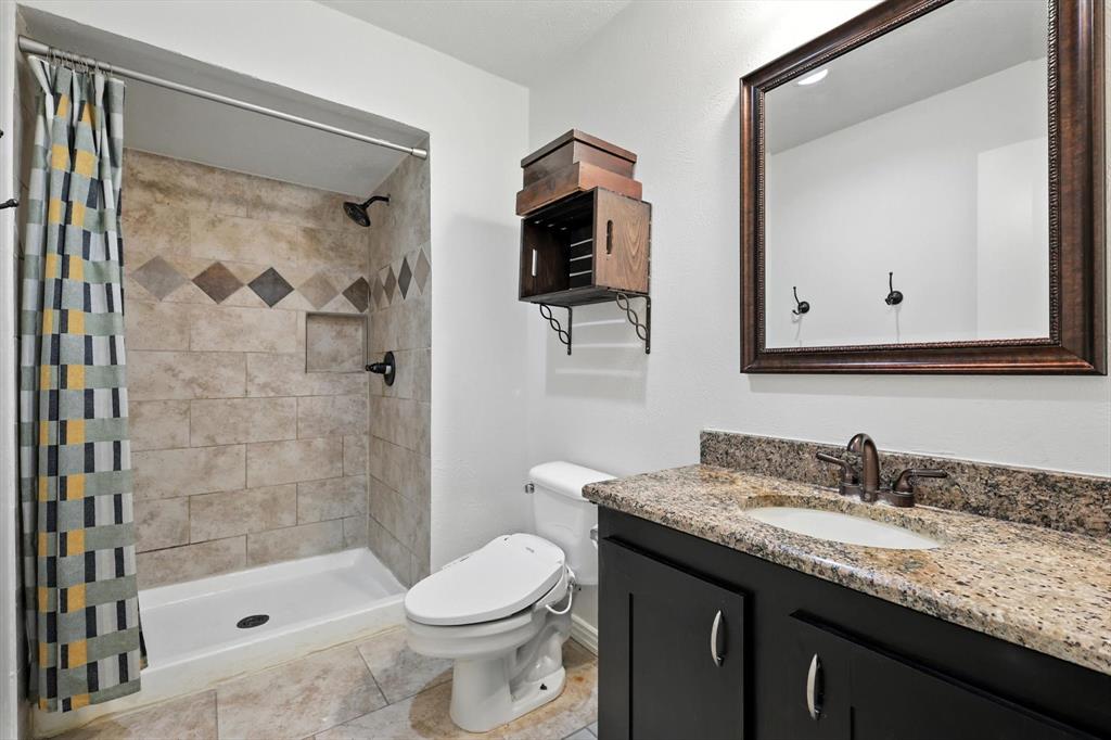 5024 Middleton Circle The Colony, TX 75056 - Photo 20 of 30 a bathroom with a granite countertop sink a mirror a bathtub and a shower