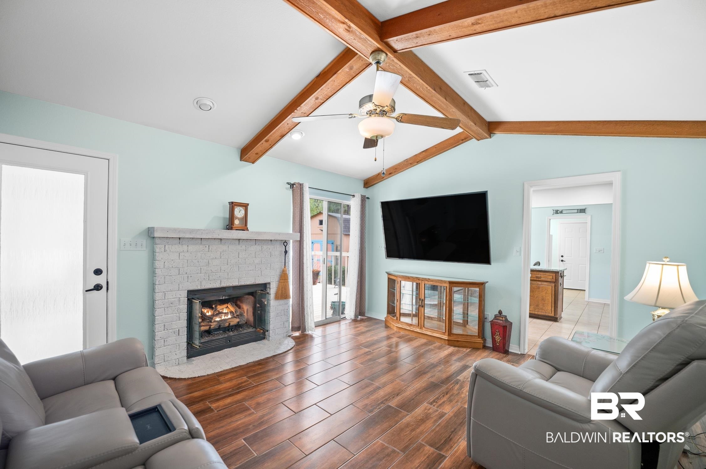 2553 Santa Rosa Drive Lillian, AL 36549 - Photo 2 of 51 Living area featuring lofted ceiling with beams, a gas fireplace, tile wood finished floors, and a ceiling fan