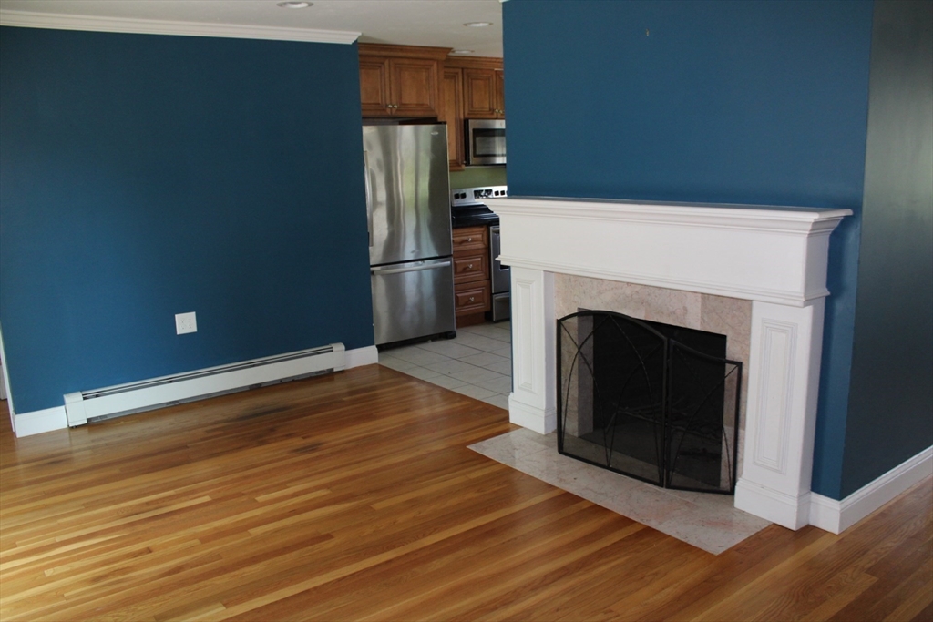 21 Whitcomb Drive Lancaster, MA 01523 - Photo 9 of 23 a kitchen with granite countertop a fireplace and a wooden floor