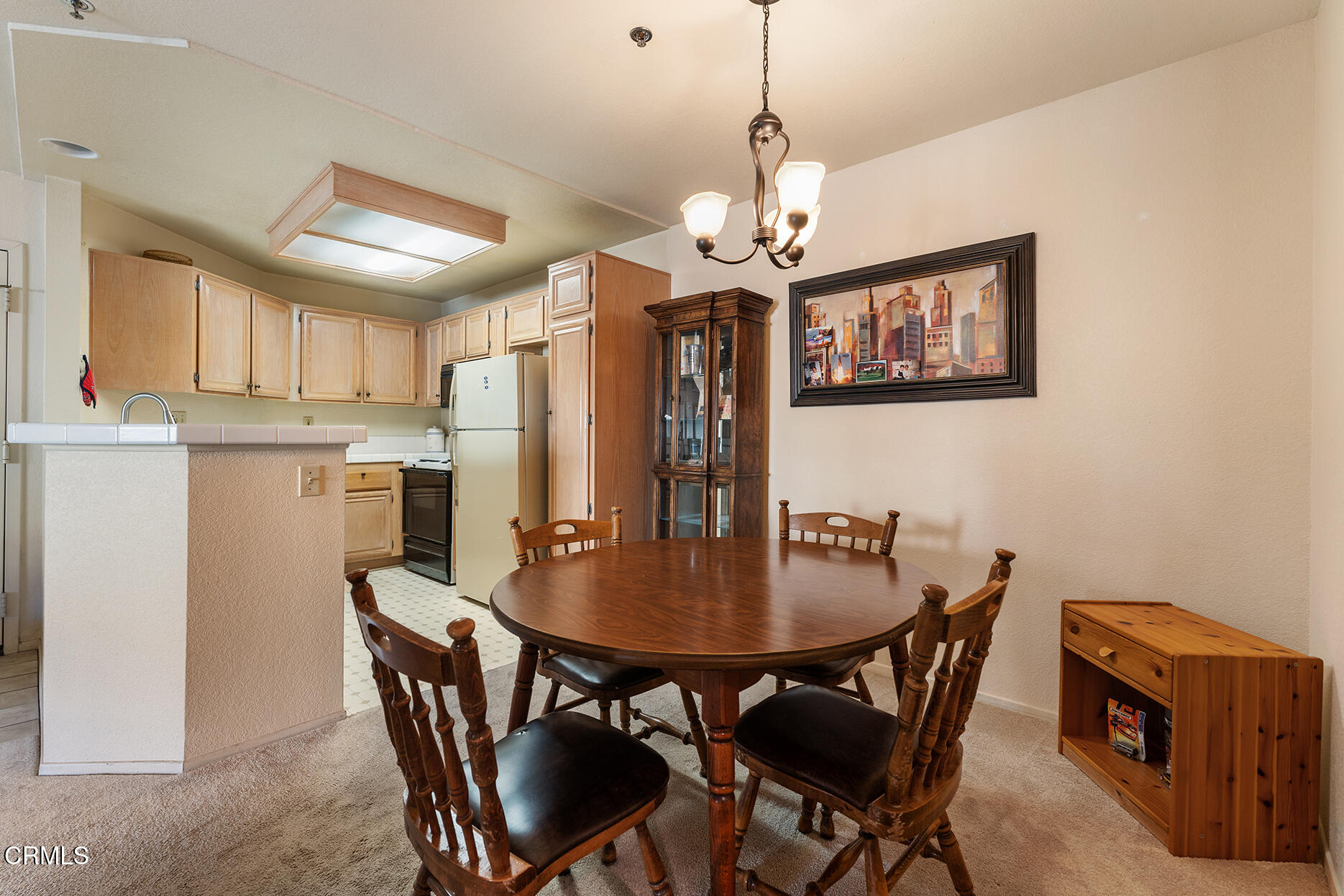 697 Sutton Crest Trail, Unit 304 Oak Park, CA 91377 - Photo 6 of 21 a view of a dining room with furniture a chandelier and wooden floor