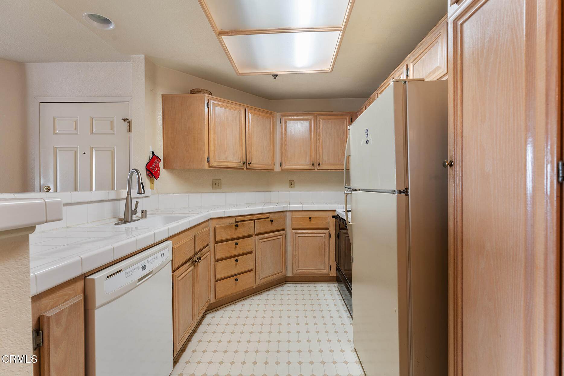 697 Sutton Crest Trail, Unit 304 Oak Park, CA 91377 - Photo 7 of 21 a kitchen with a sink cabinets stainless steel appliances and a window