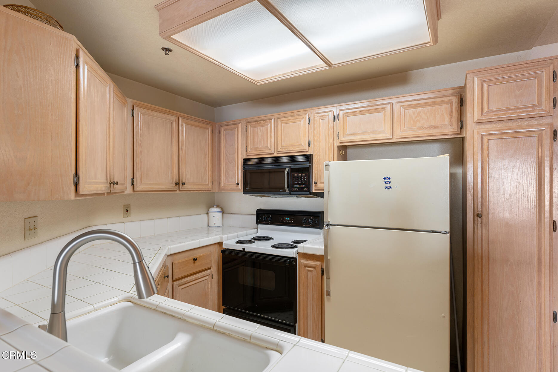 697 Sutton Crest Trail, Unit 304 Oak Park, CA 91377 - Photo 8 of 21 a kitchen with stainless steel appliances granite countertop a refrigerator sink and stove