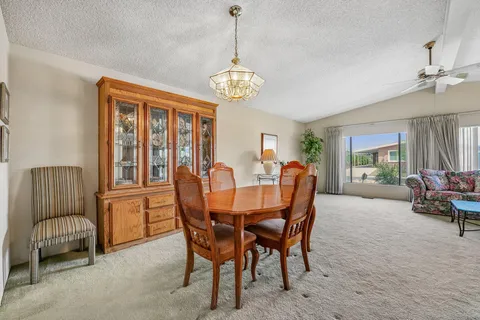 a dining room with furniture a chandelier and window