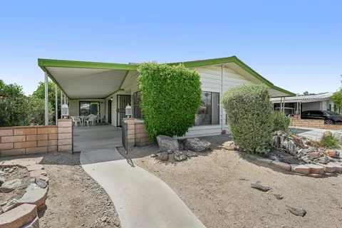 a view of a house with backyard and sitting area